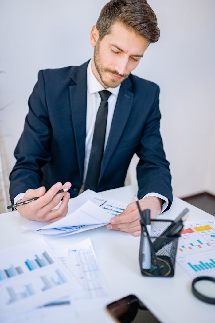 Focused businessman in a suit reviewing financial graphs at work.